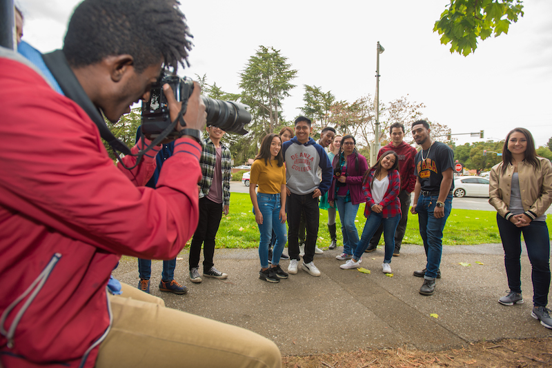 student in red jacket photographing students