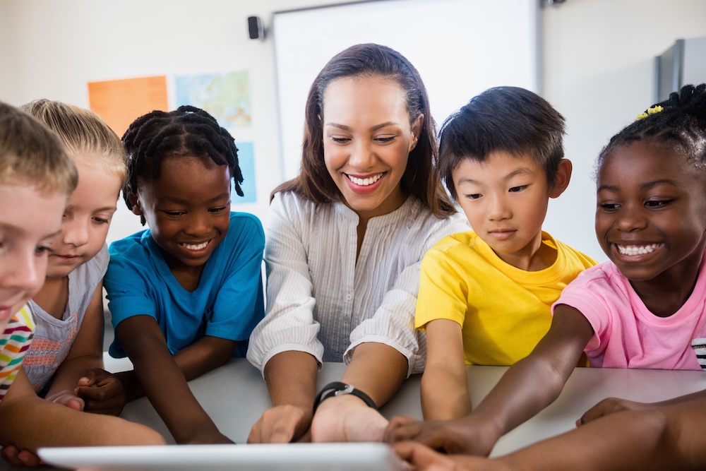 young woman teacher with several smiling children