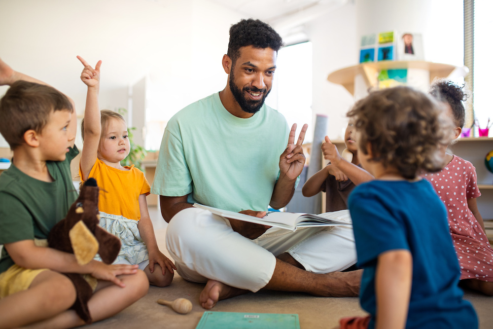 young male teacher with children