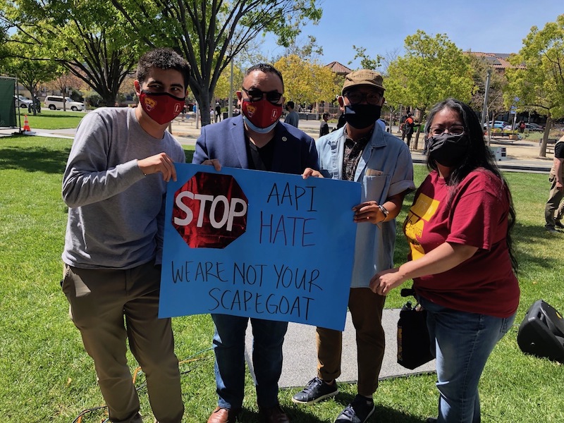 four people with signs against racism